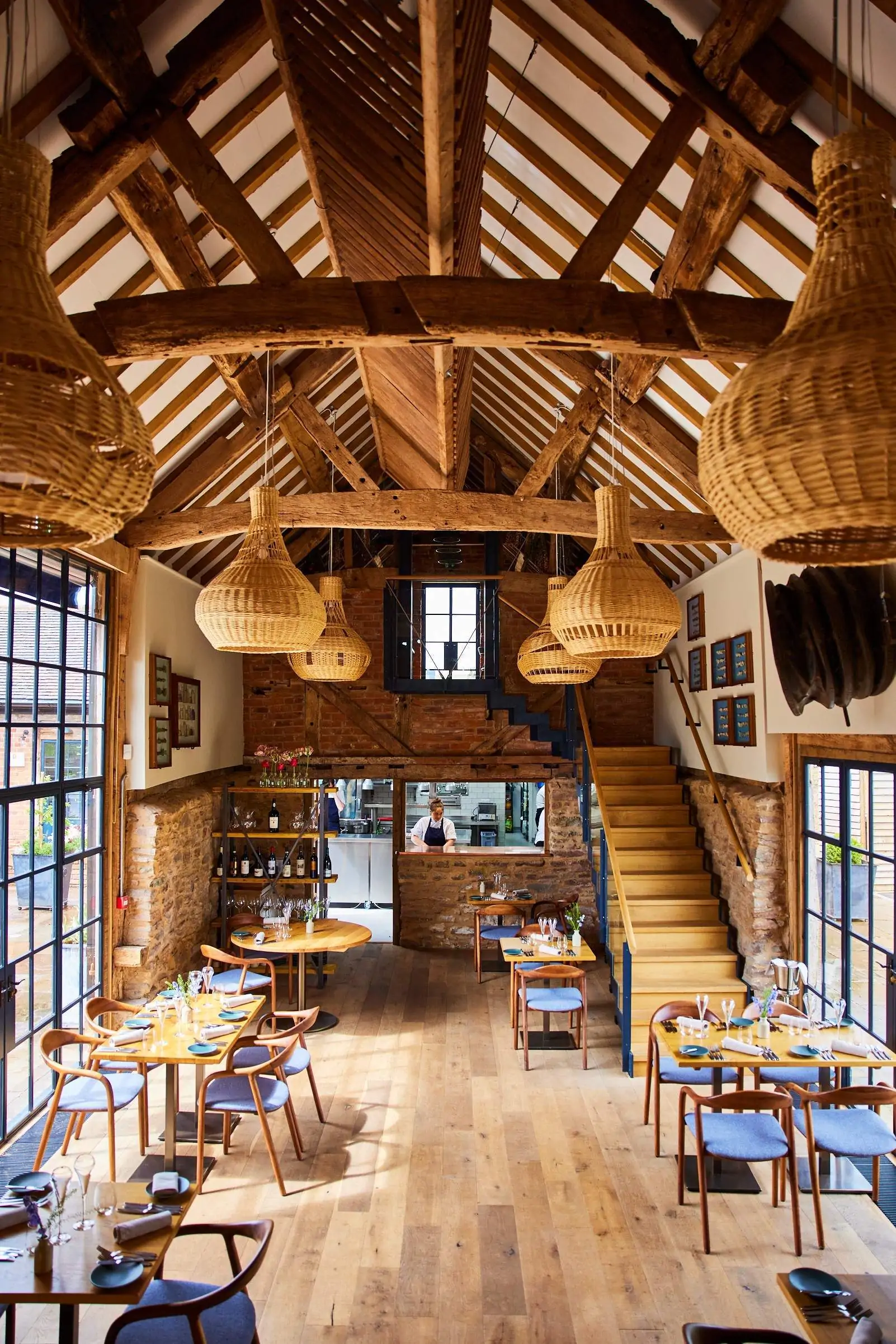 Tables set for dinner service are flanked by floor-to-ceiling windows at Pensons, a restaurant in Tenbury Wells.