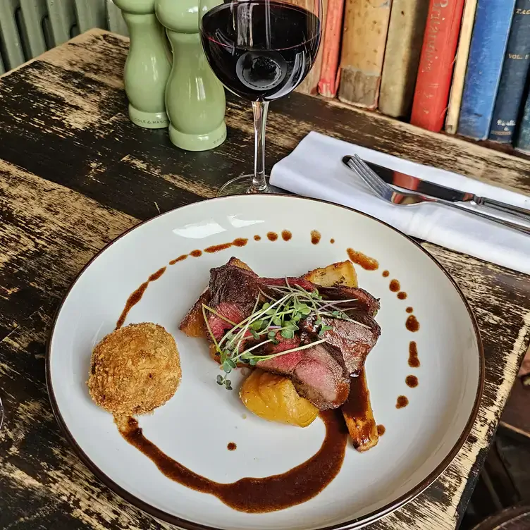 A beef dish served alongside some potatoes and a glass of red wine at The Winding Stair, one of the most romantic restaurants in Dublin.