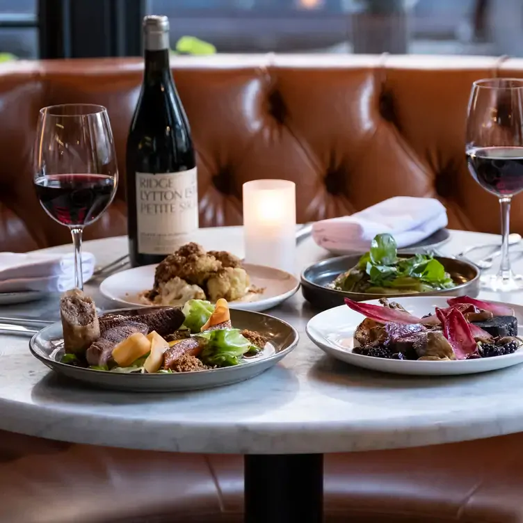 A table with different dishes, glasses of red wine and a candle at Pichet, one of Dublin’s most romantic restaurants.