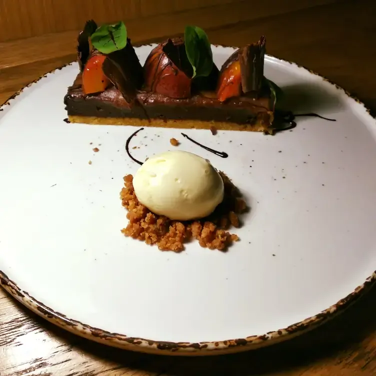 An artistically plated chocolate dessert served alongside a scoop of ice cream at Pearl Brasserie, one of the most romantic restaurants in Dublin.