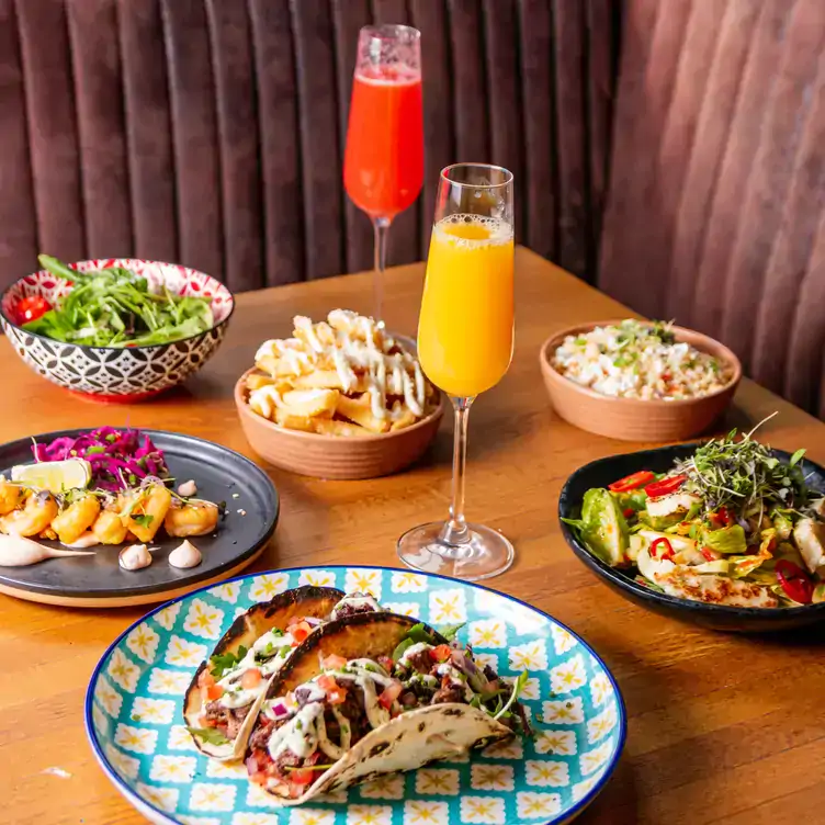 A table of different brunch dishes along with two cocktails at Cleaver East, one of the best bottomless brunch restaurants in Dublin.