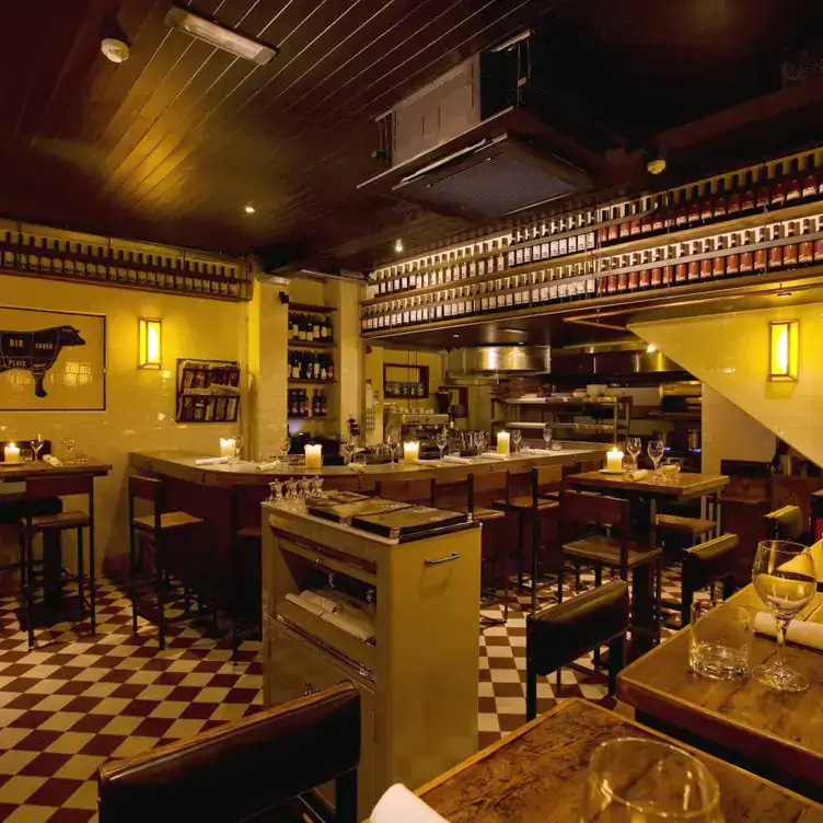 Dimli-lit interiors with a bar, high stools and bottles lined up on shelves at The Butcher Grill, one of the best restaurants near Dublin.