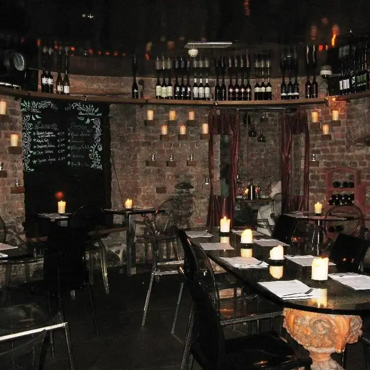 Tables with candles and a wine shelf at The Port House Dublin, one of the best places to eat in Dublin.