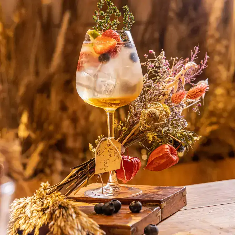 A flamboyant cocktail decorated with flowers and fruit at ALT at Wren Urban Nest, one of the best bottomless brunches in Dublin.