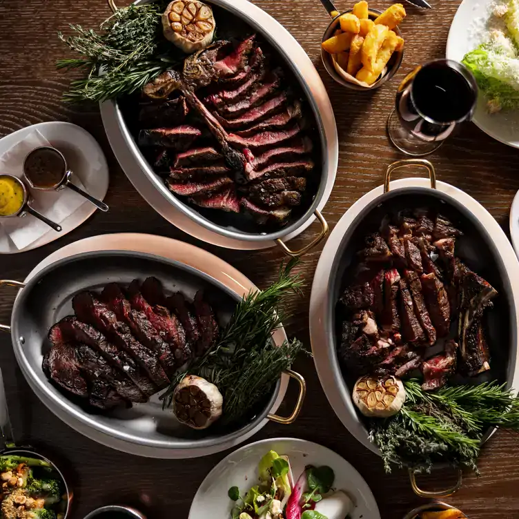 An array of steaks with chips, sauces and vegetables at Marco Pierre White Steakhouse & Grill, a restaurant in Dublin.