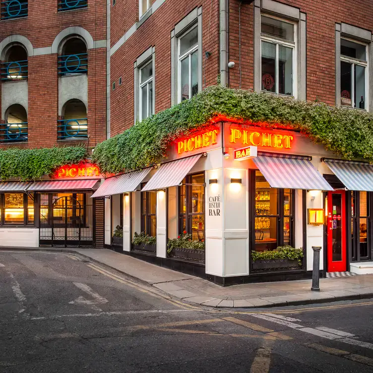 The red exterior sign and window awnings at Pichet.