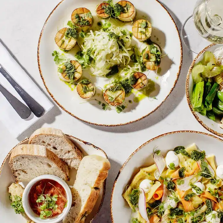 A table laid with dishes, including circular tofu, salads and bread, served at Glas, one of the best vegetarian restaurants in Dublin.